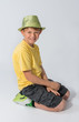 Young boy kneeling wearing a hat