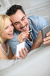 Cheerful couple having fun using smartphone