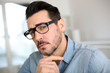 Trendy man with hand on chin looking at camera