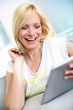 Smiling blond girl looking at tablet screen