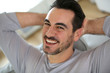 Relaxed man stretching arms behind head
