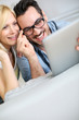 Cheerful couple websurfing on internet with tablet