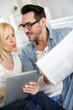 Couple reading news on both internet and paper