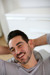 Relaxed man stretching arms behind head