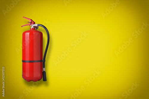 Photo: Fire extinguisher on the yellow wall Fire extinguisher on the yellow wall