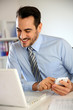 Cheerful businessman using mobile phone