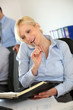 Businesswoman on the phone writing on agenda