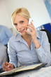 Businesswoman on the phone writing on agenda