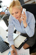 Businesswoman on the phone writing on agenda