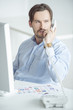 Photo: Busy businessman talking phone at his desk Busy businessman talking phone at his desk