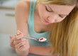 Dreamy teenager girl eating yogurt