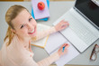 Smiling teenager girl studying in kitchen