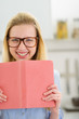 Photo: Happy teenager girl with book in kitchen Happy teenager girl with book in kitchen