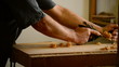 Carpenter, craftsman or luthier, with a wood planer.