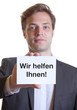Junger Mann im Anzug mit Karte WIR HELFEN IHNEN!