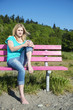 Young Woman Sitting On Bench At Beach