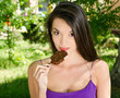 Woman eating a delicious chocolate ice cream in the park