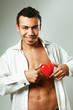 Photo: A young man holding a red heart on his hands A young man holding a red heart on his hands
