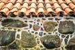 Tiled roof and wall decorated with stones.