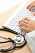 Doctor typing on keyboard with stethoscope