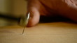 Luthier shapes the wood with hacksaw to a flamenco guitar