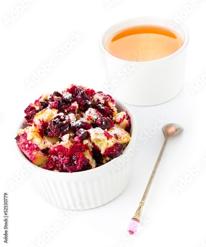 Photo: Fruit crumble dessert in a bowl with a cup of tea and teaspoon Fruit crumble dessert in a bowl with a cup of tea and teaspoon