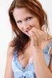 Coquettish woman biting a fingernail