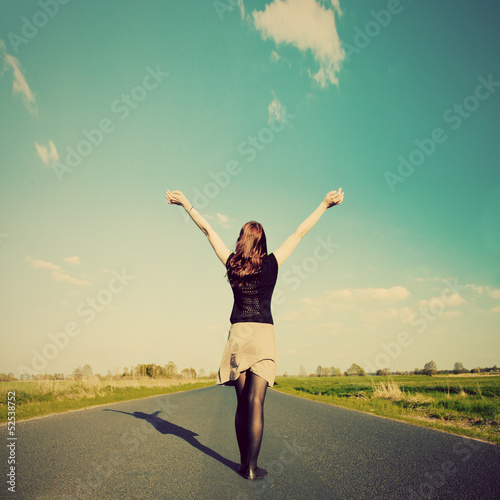 Photo: Happy woman standing on empty road. Retro vintage style Happy woman standing on empty road. Retro vintage style