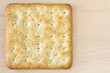 One wholegrain cracker on wooden board