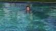 Happy young man swimming in the pool, super slow motion