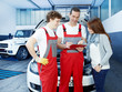 Customer and mechanics in a garage looking at a quotation