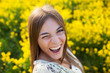 Playful young woman among yellow flowers