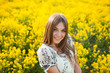 Beautiful woman among yellow flowers in a field