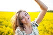 Beautiful woman among yellow flowers in a field