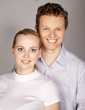 young couple standing together, posing in studio, looking at ca