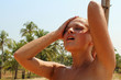 Beautiful blond woman under a beach shower