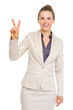 Smiling business woman showing victory gesture
