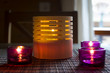 tea candles in wood and glass standing on reed mat