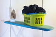 iron and laundry basket standing on ironing board