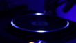 DJ's hand scratches the turntable in dark night club.