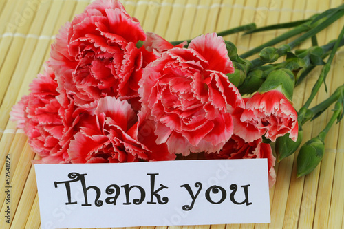 Photo: Thank you note and red and white carnations on bamboo mat Thank you note and red and white carnations on bamboo mat
