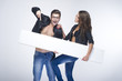 Fashionable surprised couple holding white board