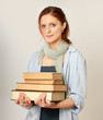 A college girl holding a pile of books, isolated on white