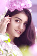 Foto: Beautiful young woman with violet flowers in spring garden Beautiful young woman with violet flowers in spring garden