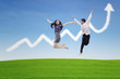 Couple jumping on profit chart cloud