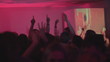 Dj cheering up the crowd, audience wave their hands in return