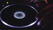 DJ is tweaking the turntable, performing at night party