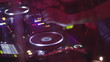 Hands of female Dj playing set performing at party in night club