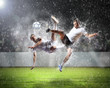 two football players striking the ball