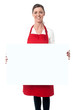 Photo: Lady wearing apron holding white blank ad board Lady wearing apron holding white blank ad board